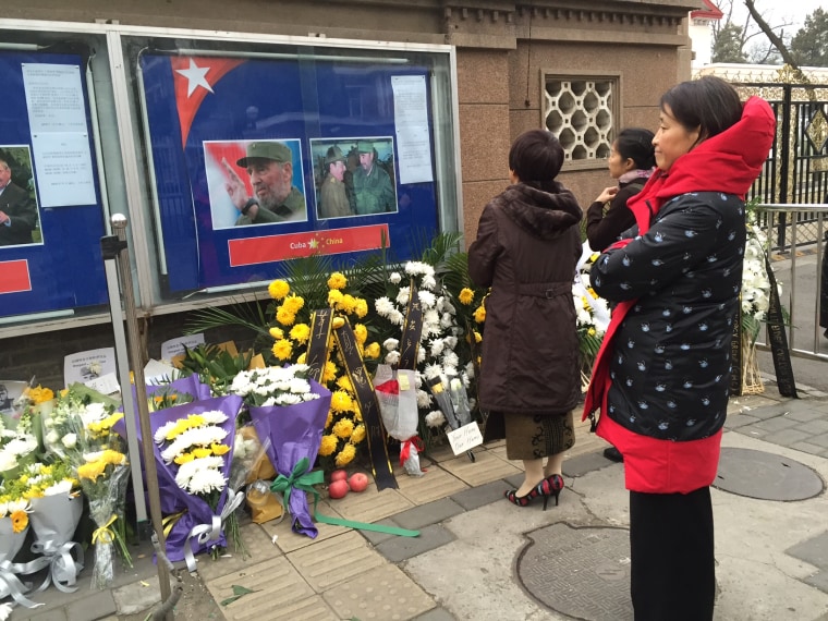 Image: Women stand at a memorial for Fidel Castro at the Cuban embassy in Beijing