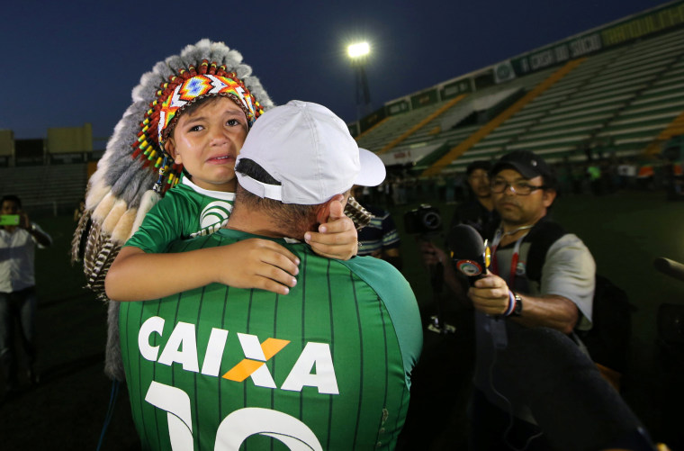 Image: A fan of Chapecoense soccer team and his son react at the Arena Conda stadium in Chapeco
