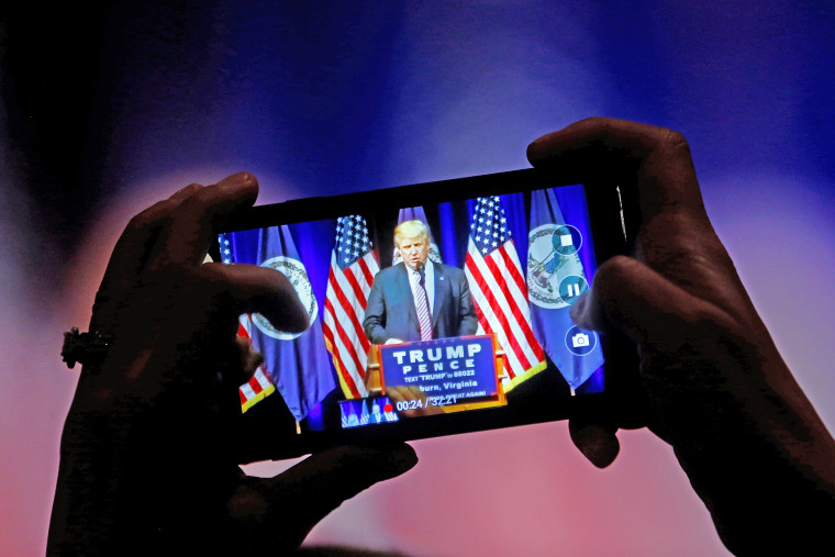 A supporter photographs Republican U.S. Presidential nominee Donald Trump during a campaign event at Briar Woods High School in Ashburn