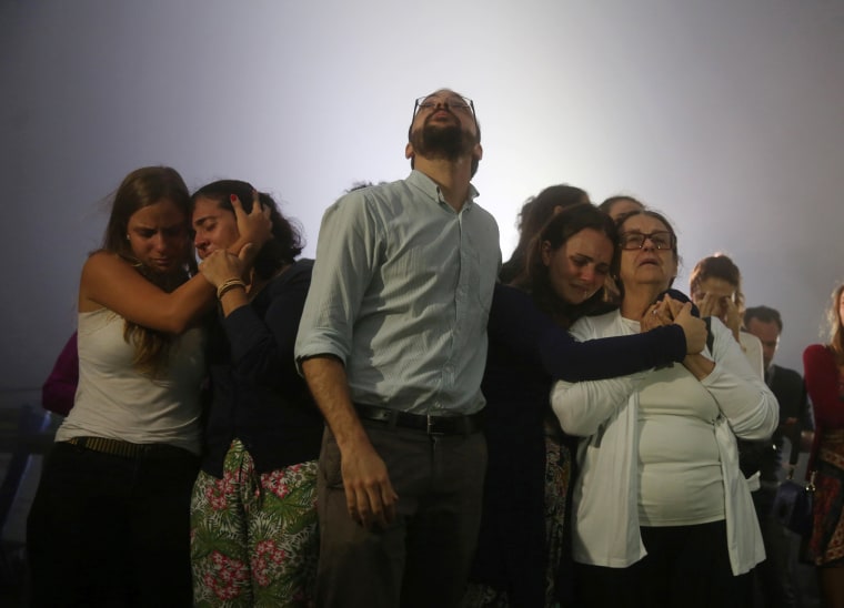 Image: Relatives of Brazilian journalist Guilherme Marques mourn during a mass in Rio de Janeiro