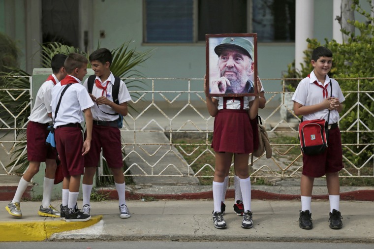 Image: Children stand along a street while waiting for the ashes of Fidel Castro to pass in Cardenas
