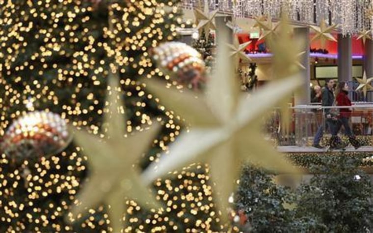 Shoppers walk among illuminated Christmas decorations in a shopping mall at Berlin's Potsdamer Platz