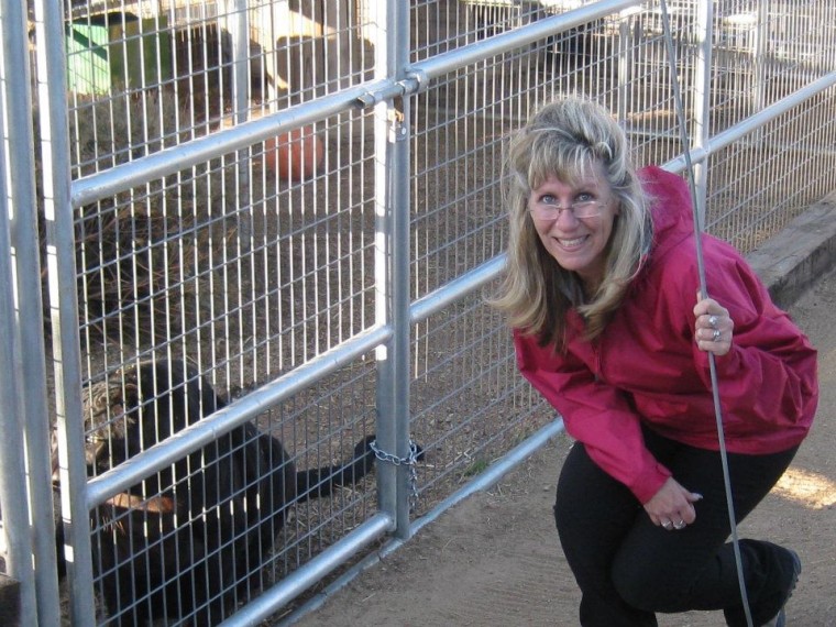 Jennifer Wright next to a black leopard’s cage at Forever Wild Animal Rescue in Phelan, California, where she often takes her students on field trips.