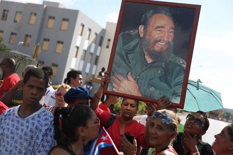 Image: Crowds hold pictures of Fidel Castro as they await the convoy of vehicles escorting his remains near the Moncada Barracks on Saturday.