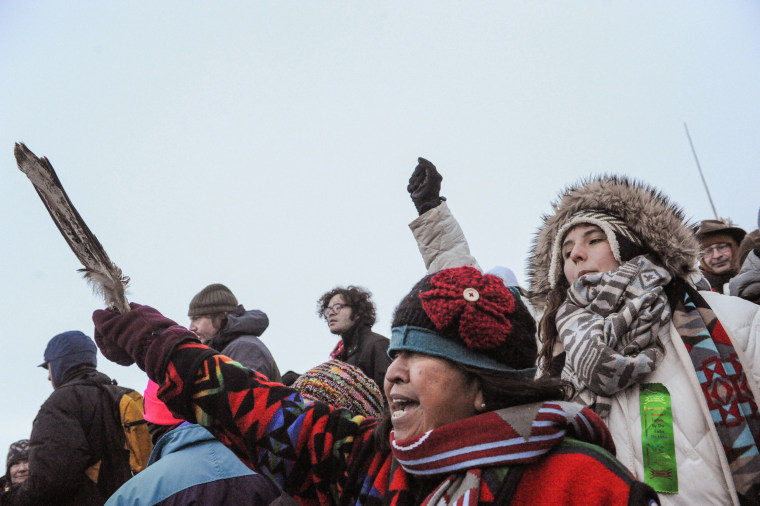 Image: A woman from the Tlingit Tsimphean tribe holds an eagle feather into the air in Oceti Sakowin camp as "water protectors" continue to demonstrate against plans to pass the Dakota Access pipeline near the Standing Rock Indian Reservation, near Cannon