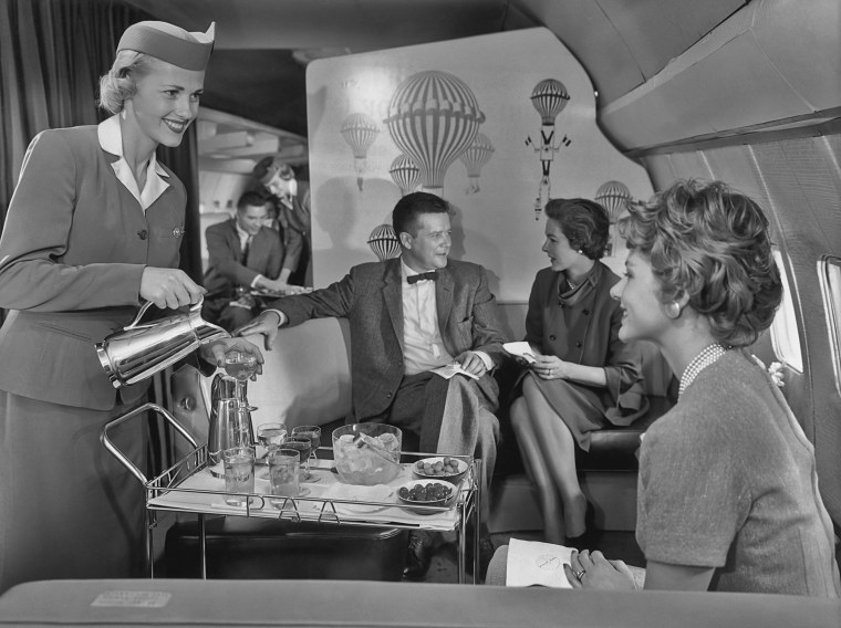 Image: A flight attendant serves cocktails in the lounge of a new Pan American World Airways (Pan Am) Boeing 707, circa 1958.