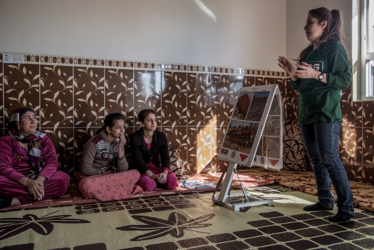 Image: Women in the village receive life-saving lessons from Mines Advisory Group (MAG), including how to distinguish between the many types of deadly explosives left behind by ISIS.