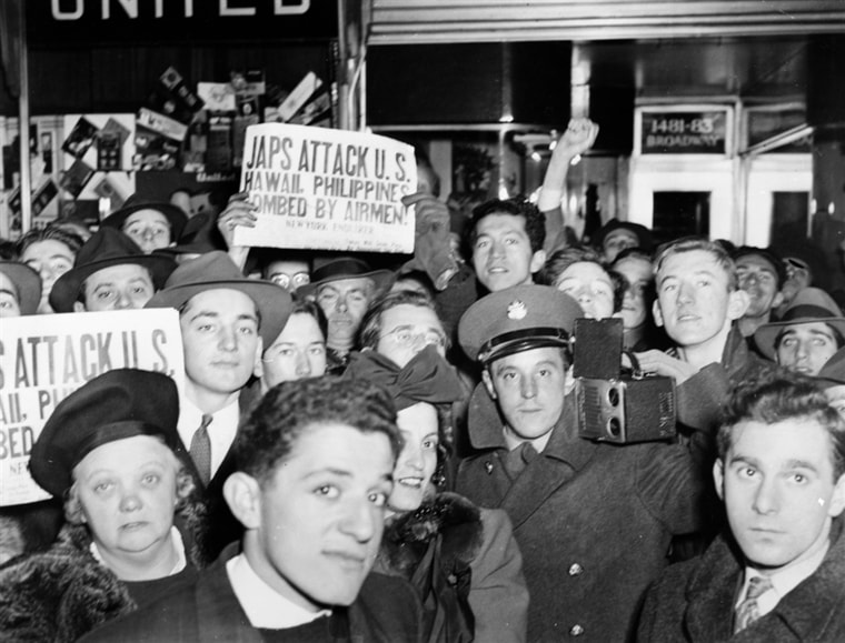 Image: A crowd on Broadway in New York City hold up newspapers announcing the Japanese attack on Pearl Harbor.