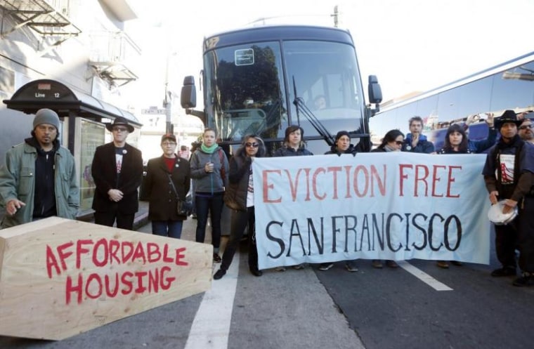 Protesters block a bus full of Apple employees during a protest against rising costs of living in San Francisco