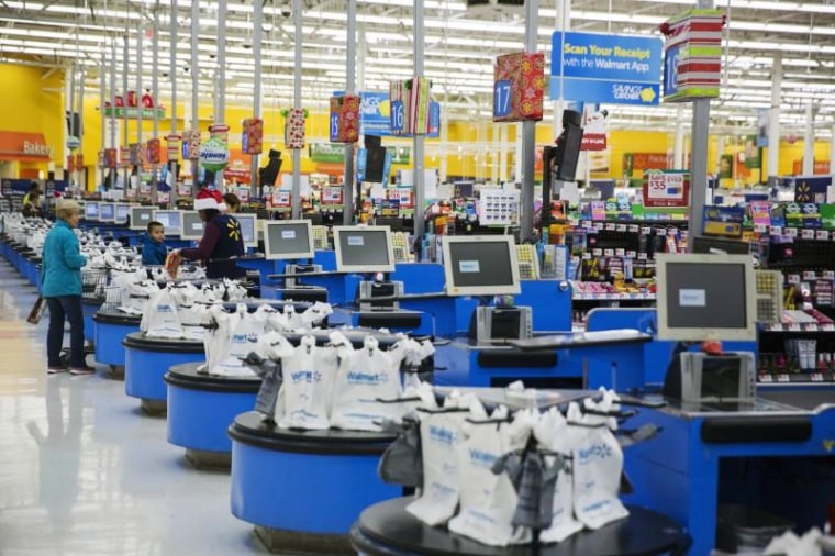 Employees work at the checkout counters of a Walmart store in Secaucus, New Jersey