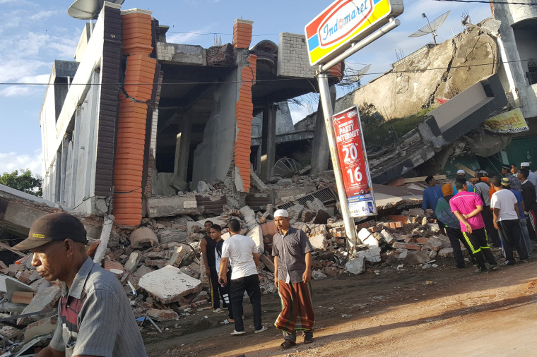 Image: People survey the damage after dozens of buildings collapsed following a 6.4 magnitude earthquake in Ule Glee, Pidie Jaya in the northern province of Aceh, Indonesia
