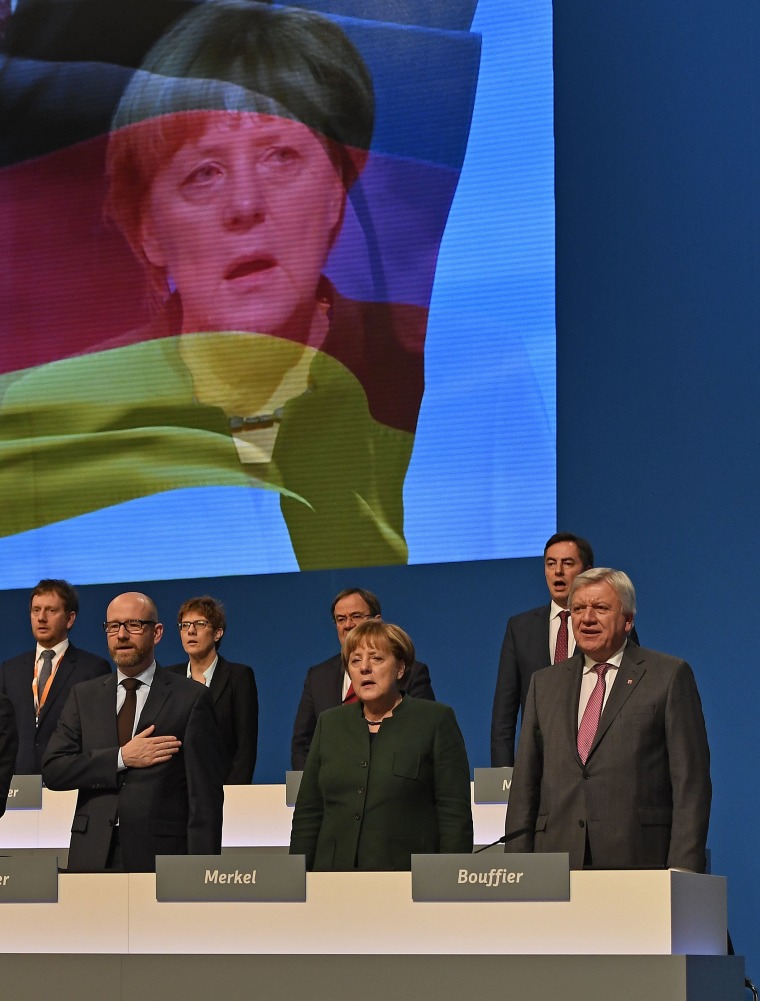 Image: CDU leaders including Angela Merkel, second right, sing the national anthem at the party conference in Essen, Germany.