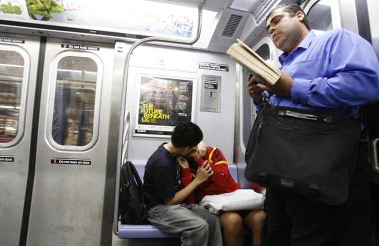 Couple kisses while riding the subway in New York