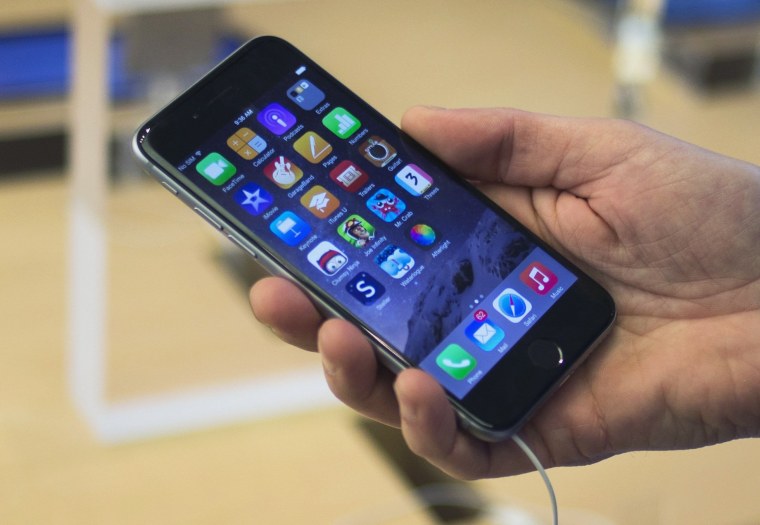 Image: A customer holds an iPhone 6 on display at the Fifth Avenue Apple store on the first day of sales in Manhattan.
