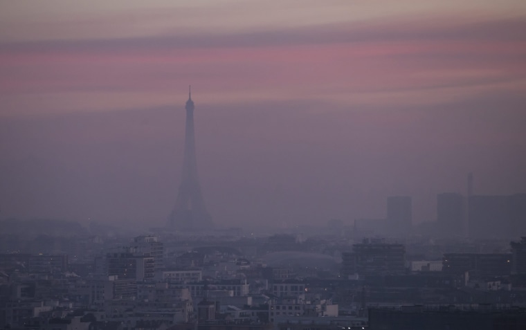 Image: The Eiffel tower is shrouded in haze as the sun comes up