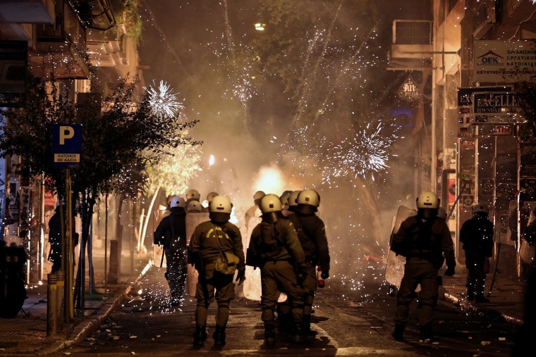 Image: Fireworks explode next to riot police during clashes following an anniversary rally marking the 2008 police shooting of 15-year-old student, Alexandros Grigoropoulos, in Athens