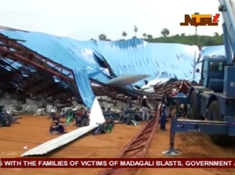 Image: People gather around the remains of a church that collapsed