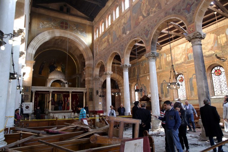 Image: Security officials and people inspect the damage inside St. Peter and St. Paul Coptic Orthodox Church