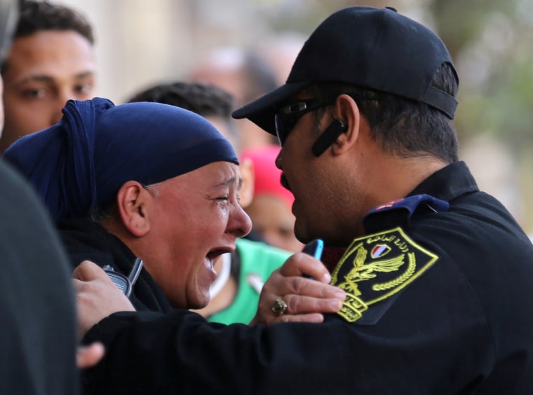 Image: A relative of one of the blast victims screams at a police officer in front of St. Mark's Coptic Orthodox Cathedral after an explosion inside the cathedral in Cairo