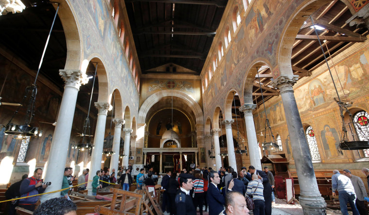 Image: Egyptian security officials and investigators inspect the scene following a bombing inside Cairo's Coptic cathedral in Egypt