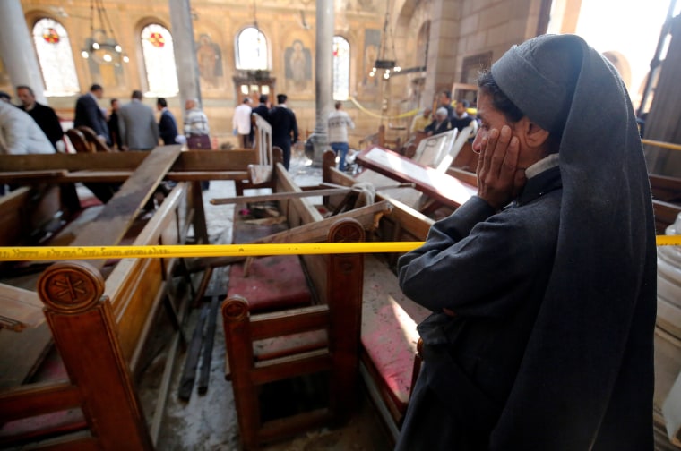Image: A nun cries as she stands at the scene inside Cairo's Coptic cathedral, following a bombing, in Egypt