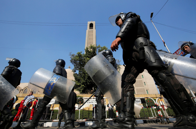 Image: Members of the special police forces stand guard to secure the area around Cairo's Coptic cathedral after an explosion inside the cathedral, Egypt