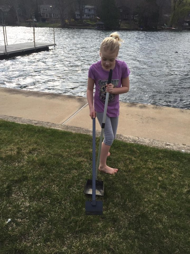 Willow Phelps cleans up goose droppings around a lake near her home.