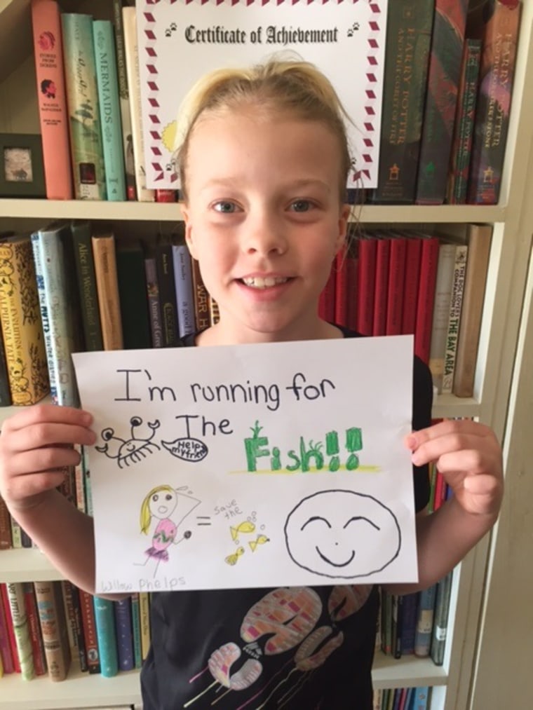 Willow Phelps holds her drawing about helping goldfish.