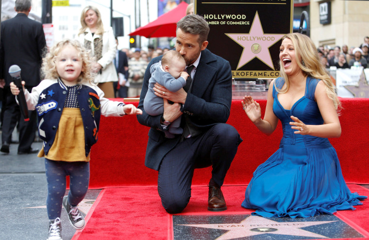 Reynolds kisses his daughter while posing by his star with his wife Lively and their daughter James on the Hollywood Walk of Fame in Hollywood