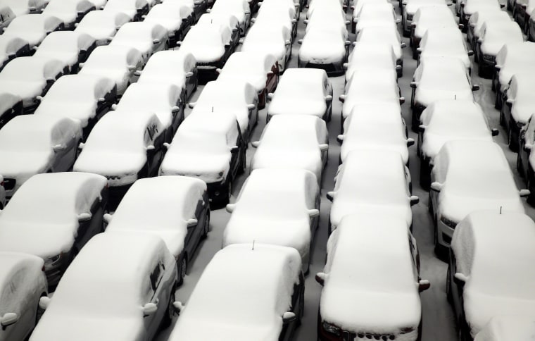 Image: Snow covers vehicles in a rental car parking lot at O'Hare International Airport