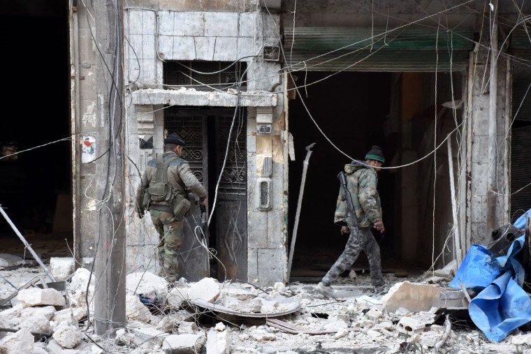 Image: Pro-government forces inspect a building in eastern Aleppo Sunday after retaking it from rebel fighters.