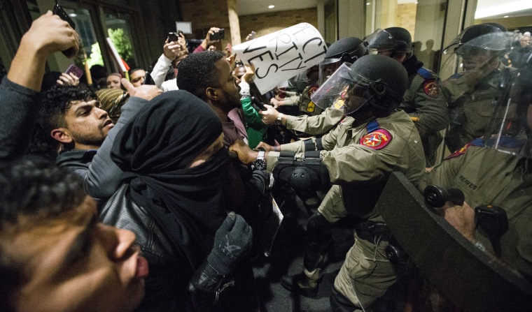 Law enforcement officers push protesters out of the Texas A&amp;M University student center