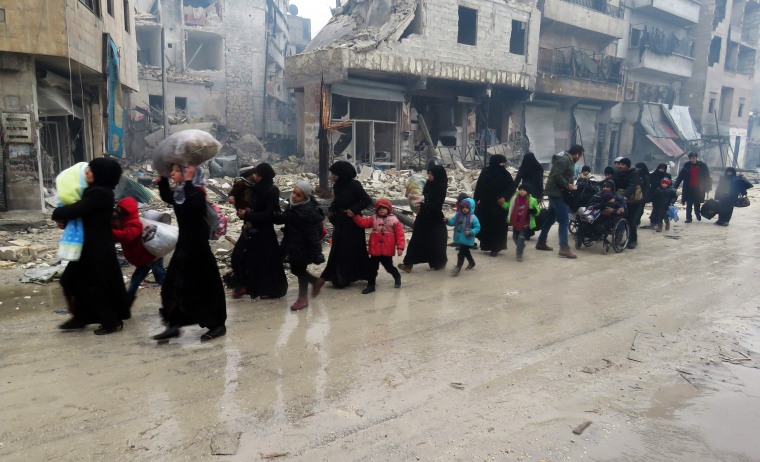 Image: Syrian residents, fleeing violence in the restive Bustan al-Qasr neighborhood, arrive in Aleppo's Fardos neighborhood on Dec. 13 after regime troops retook the area from rebel fighters.