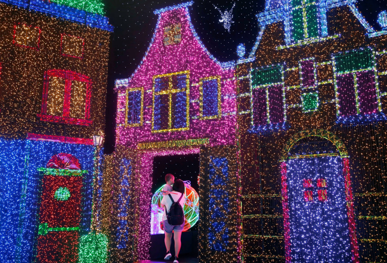 Image: People tour a Christmas attraction featuring a display of more than 800,000 light bulbs in Universal Studios Singapore