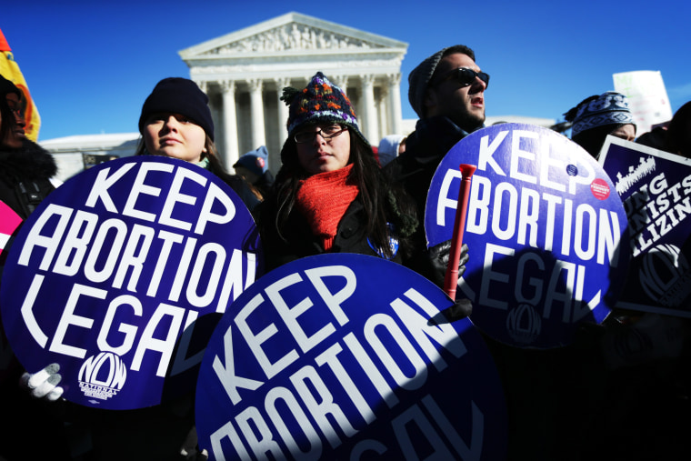 Image: Pro-choice activists hold signs in front of the U.S. Supreme Court on Jan. 22, 2014 on Capitol Hill in Washington, D.C.