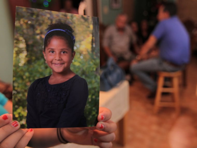 In this file photo from December 14, 2012, in Maunabo, Puerto Rico, a relative at the house of Elba Marquez, grandmother of 6-year-old Ana Marquez-Greene, holds a photo of the little girl who was killed in the Newtown school shooting. Her father, renowned jazz musician Jimmy Greene, is producing an album in Ana's honor called "Beautiful Life."