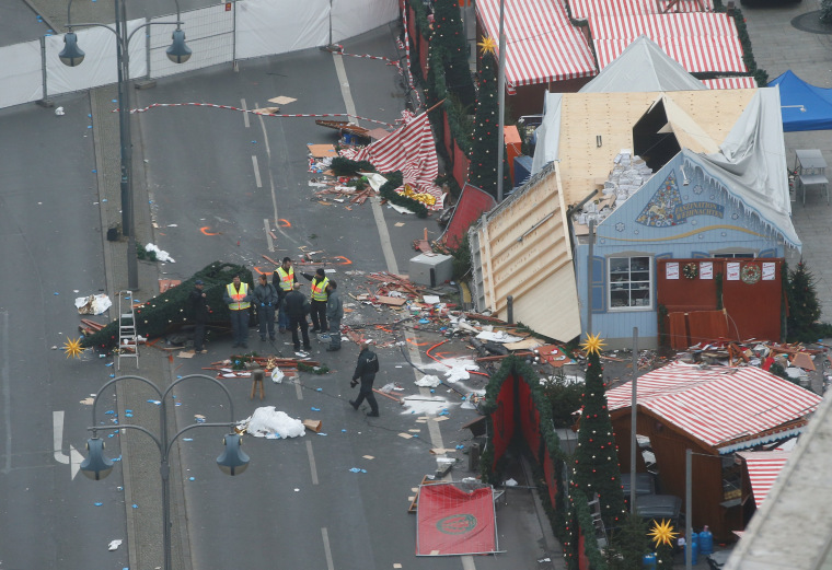 Image: Policemen investigate the scene where a truck ploughed into a crowded Christmas market in the German capital last night in Berlin