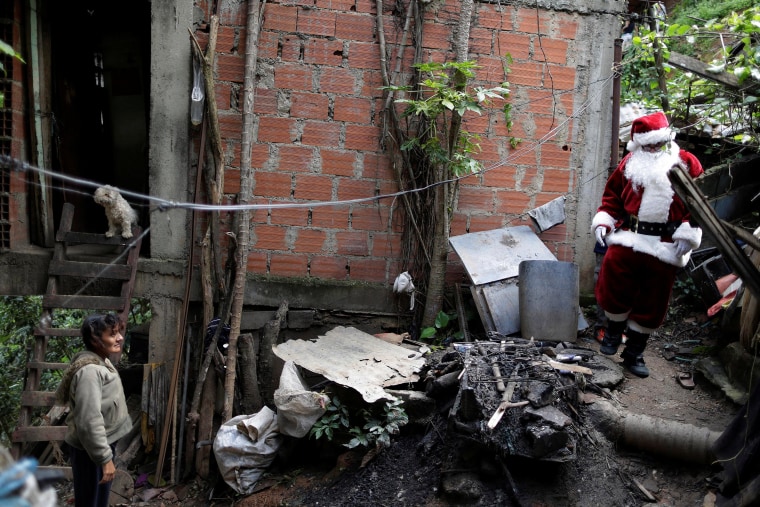 Image: Santa Claus walks during a visit to residents of the slum of Petare in Caracas