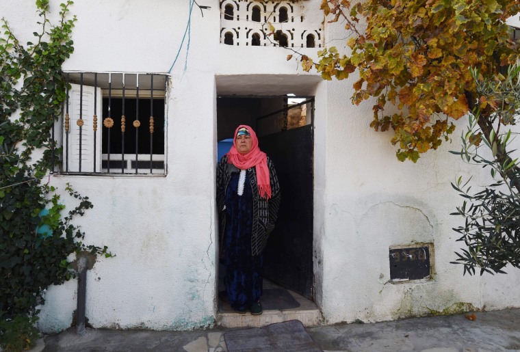 Image: The mother of 24-year-old Anis Amri stands outside her home