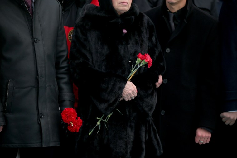 Image: Marina, the wife of Russian Ambassador to Turkey Andrei Karlov who was assassinated Monday, holds flowers during a ceremony at the airport in Ankara, Turkey, Dec, 20.