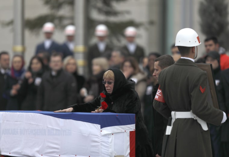 Image: Late Russian Ambassador to Turkey Andrei Karlov's wife Marina reacts next to the flag-wrapped coffin during a ceremony at Esenboga airport in Ankara, Turkey, Dec. 20.