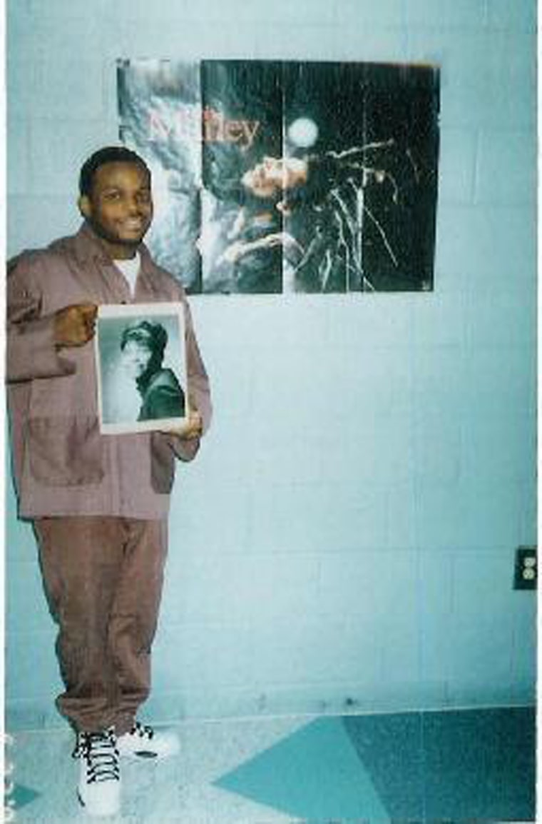 Image: Jimmy Dennis poses while holding a photograph of his mother.