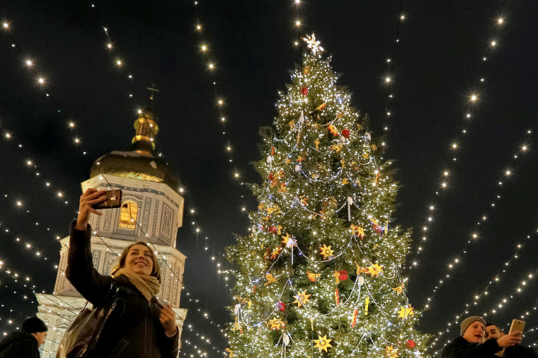 Image: People take pictures next to an illuminated Christmas tree in front of the St. Sophia Cathedral in central Kiev, Ukraine, Dec. 21.