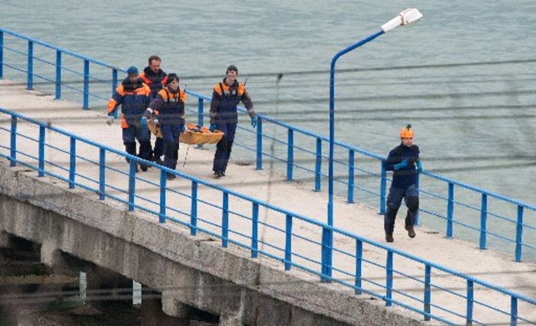 Image: Russian rescuers carry a stretcher with a body