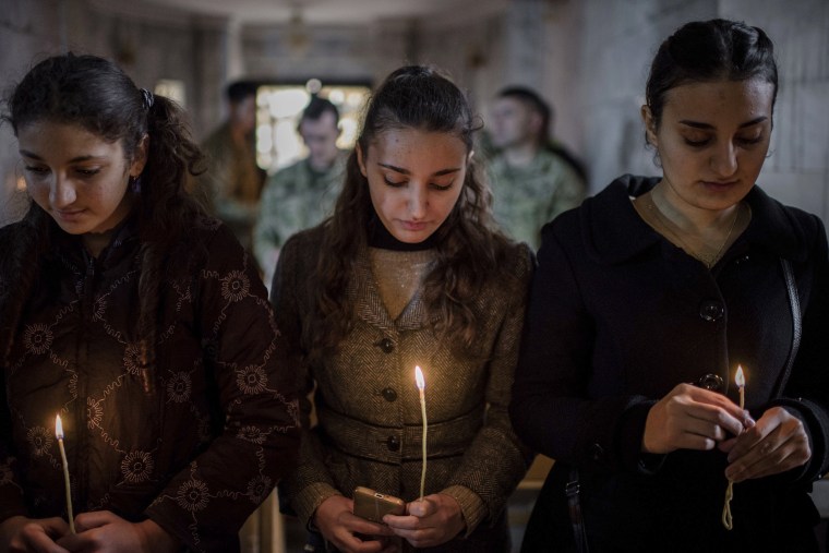 Image: Iraqis attend Christmas Eve's Mass in the Assyrian Orthodox church of Mart Shmoni