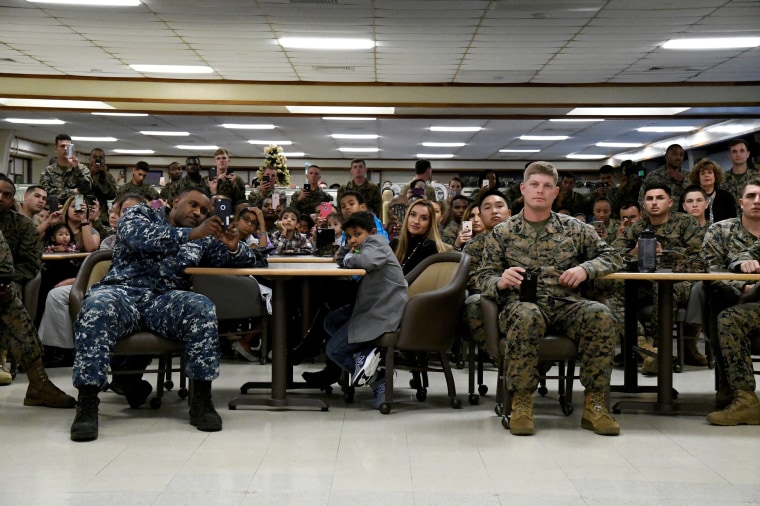 Image: U.S. military personnel and their families listen as U.S. President Barack Obama and First Lady Michelle Obama speak on Christmas day at Marine Corps Base Hawaii in Kailua