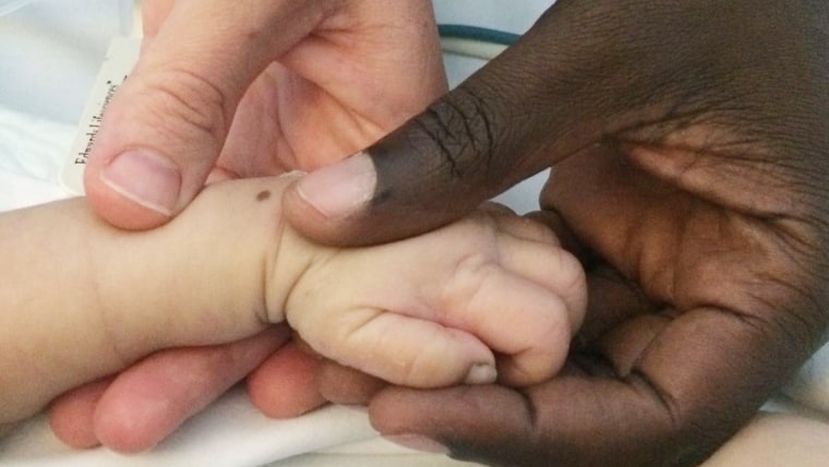 Theo Omondi holds hands with his parents.