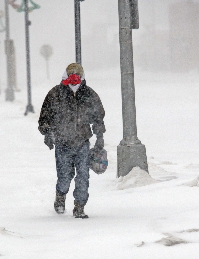 Chris Barrett walks in low visibility conditions in downtown Mandan, N.D., during the Christmas Day blizzard on Sunday, Dec. 25, 2016. Most of the Dakotas and southwest Minnesota had turned into a slippery mess due to freezing rain Sunday morning before snow arrived later in the day as temperatures fell.