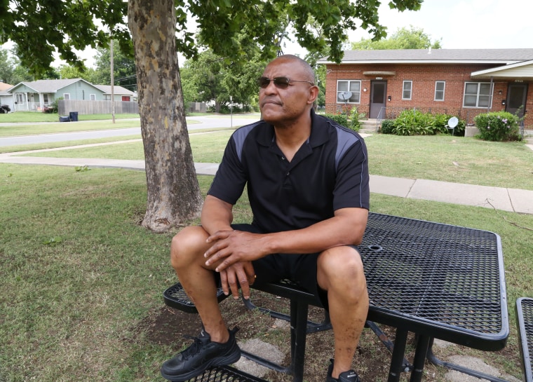 Image: Thomas Webb sits at a table he uses as a meditation area outside his home in Oklahoma City