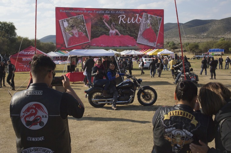 Image: A couple, who traveled from Mexico City with a group of bikers, pose for a photo at Rubi's quinceanera